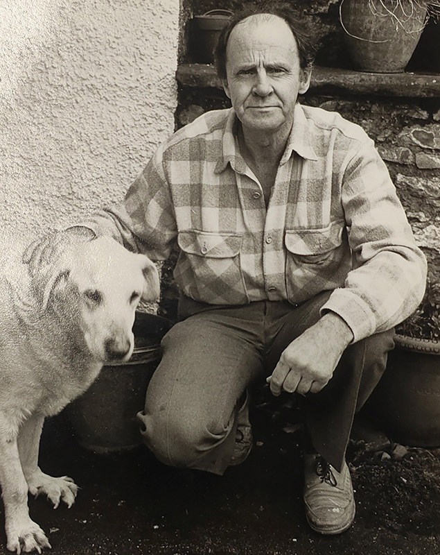 David crouching down beside his labrador dog.