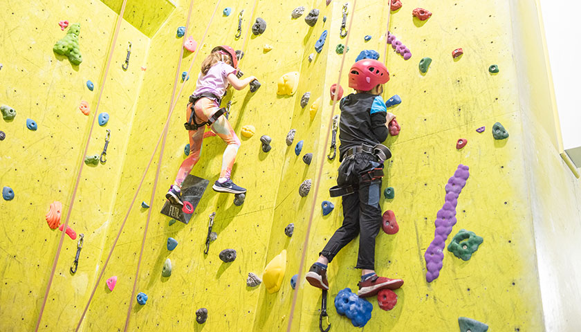 Children using the climbing wall at the Sports Centre