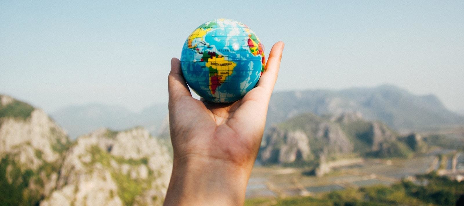 Hand holding a small palm-sized globe