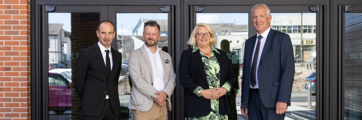 Four people standing in the foyer of a building