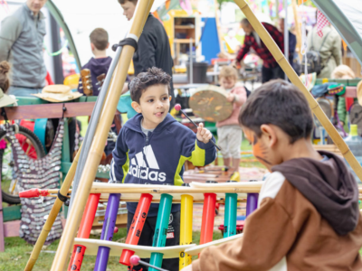 some children play with large wooden musical instruments
