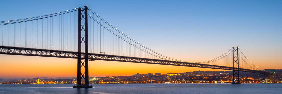 Ponte 25 de Abril Suspension Bridge over Tagus River at evening sunset