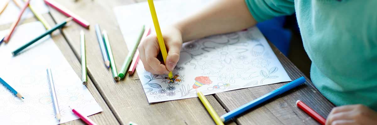 Child drawing colouring in with pencils