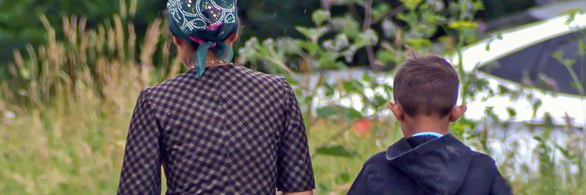 mother and son of Roma heritage walking in a field