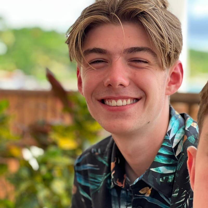 Alex, a student, smiling and staring forwards