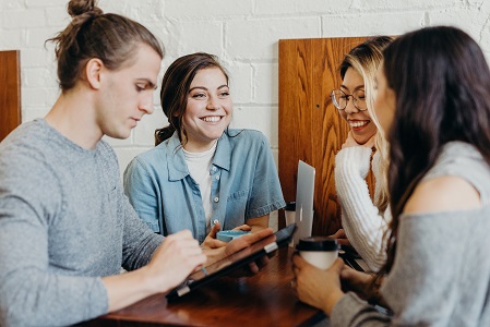 Group of students sitting around a table chatting.