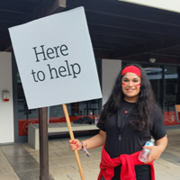 Image of Zehra Bari holding u a square sign