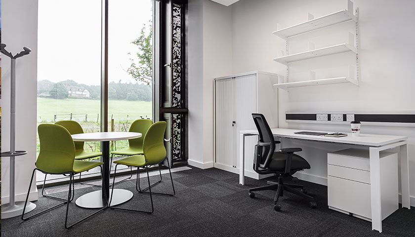 An office space with an extra desk and 4 chairs 