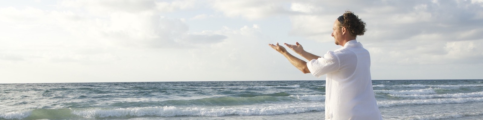 Man performing Tai Chi on a beach