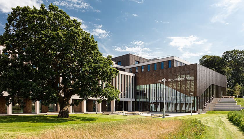The Health Innovation Campus building view from front with large tree
