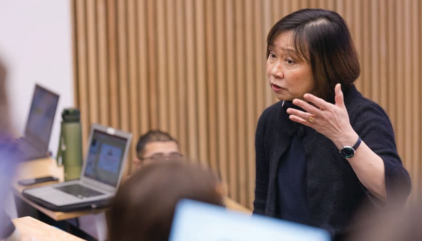 A lecturer talking at the front of a lecture theatre