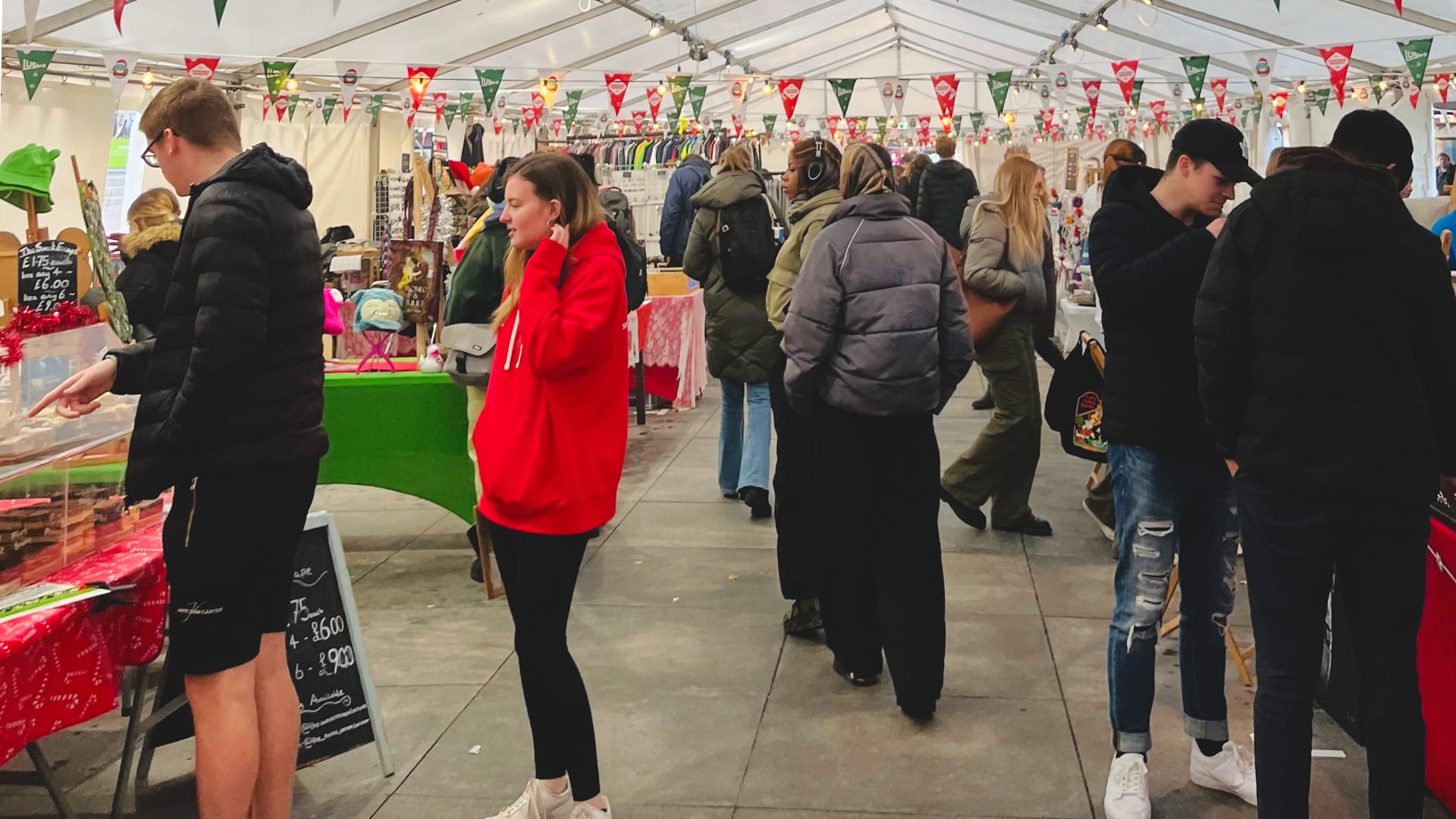 A photo showing crowds inside a marquee with Christmas stalls down either side