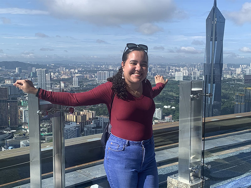 Student Lyea poses in front of Malaysia skyline