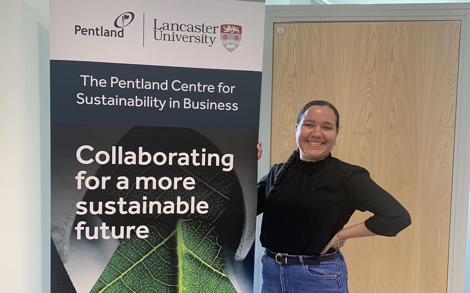 Student Lyea poses with a banner 