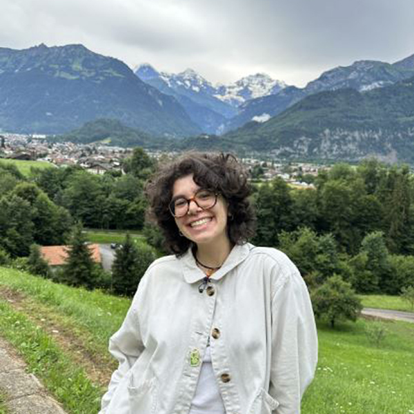 Student smiling with mountains in the background