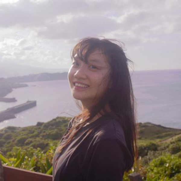 Student smiling at the camera with ocean behind her 