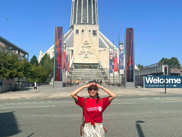 A person standing in front of Liverpool Metropolitan Cathedral. 