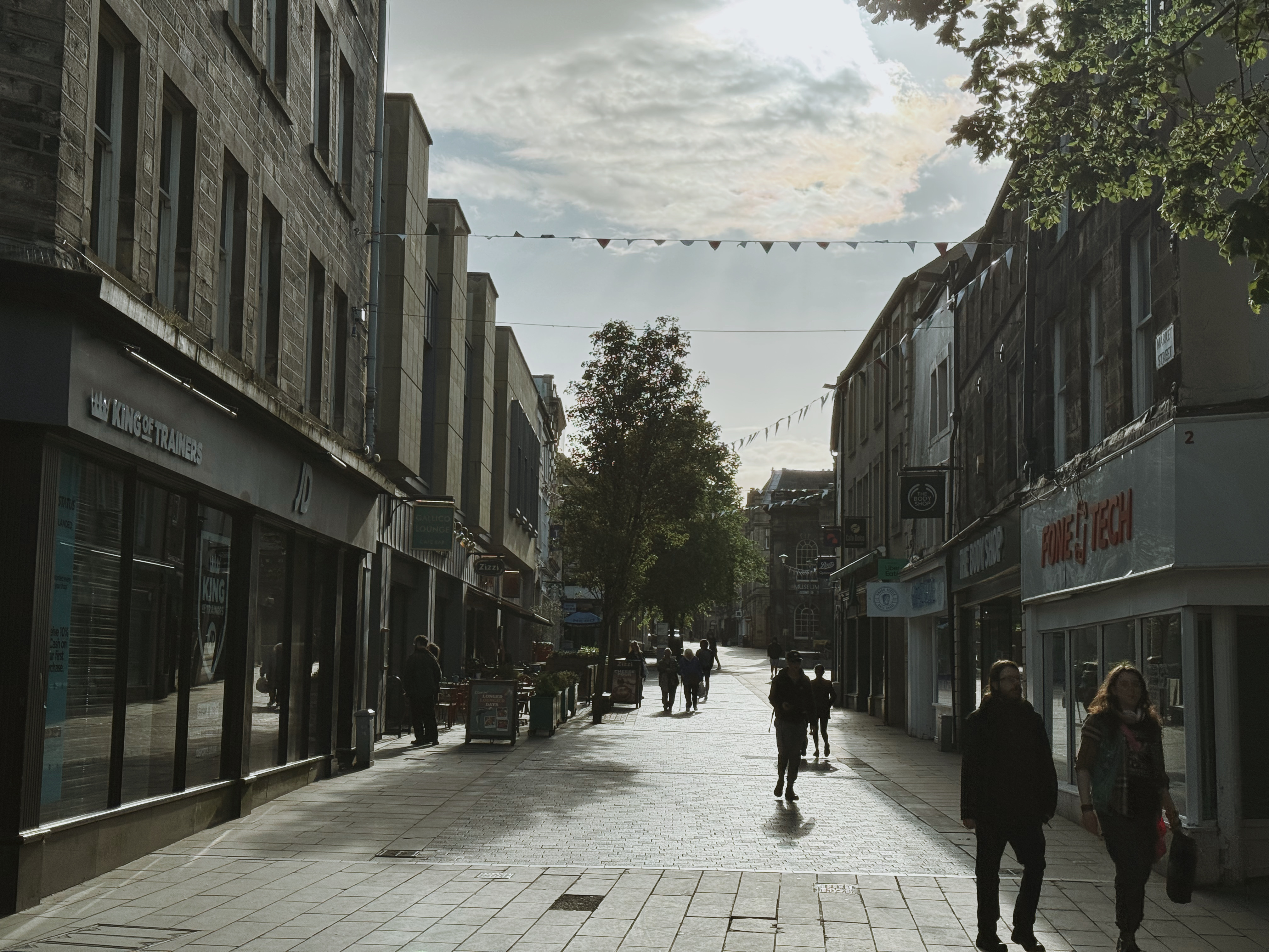 People walking along the street in Lancaster town centre under a nice weather. 