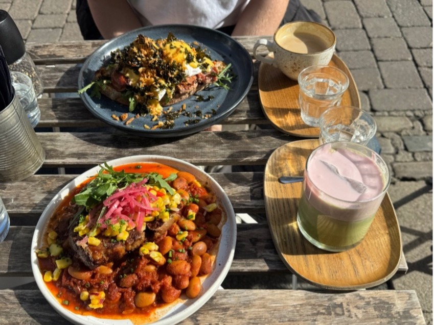 Two colourful dishes from journey social in Lancaster with two drinks on the side on a sunny day.