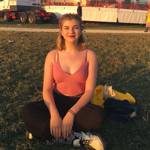 Student sitting on the grass at a festival