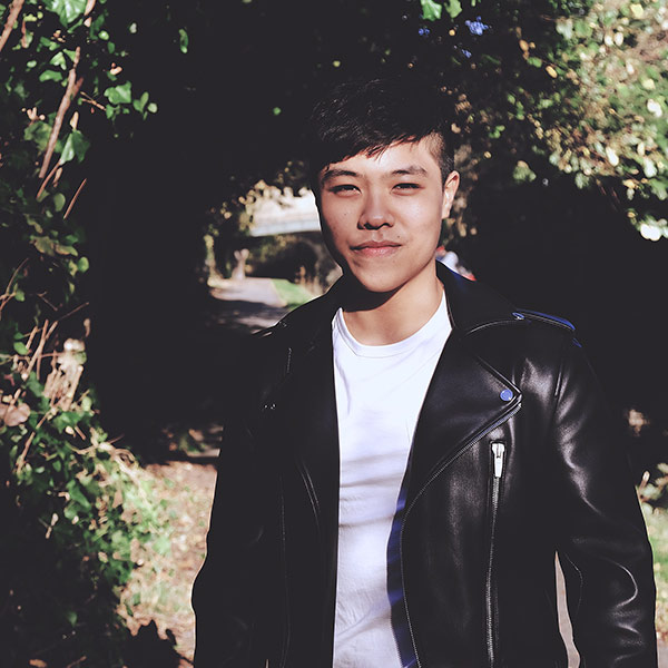 Student standing in front of a tree