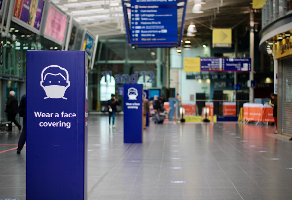 Signs at train station requesting customers wear a face covering