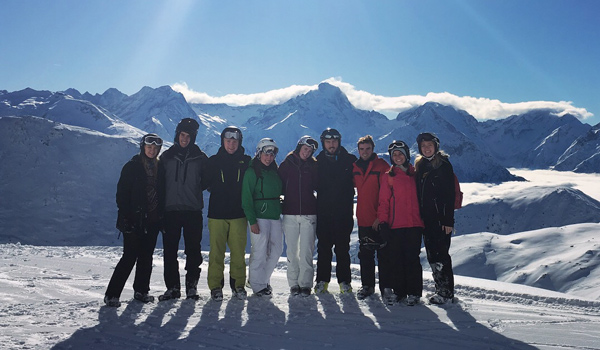 9 skiers at the top of a mountain
