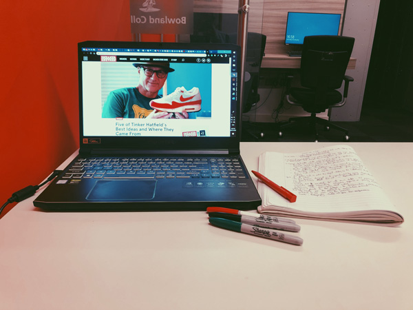 A laptop, notebook and pens