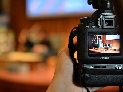 Picture of a video recorder in the foreground recording activities going on in a classroom 
