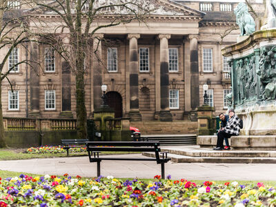 Lancaster city centre students sat on monument in front of building