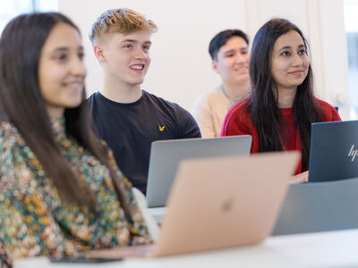 Group of four students in seminar with laptops