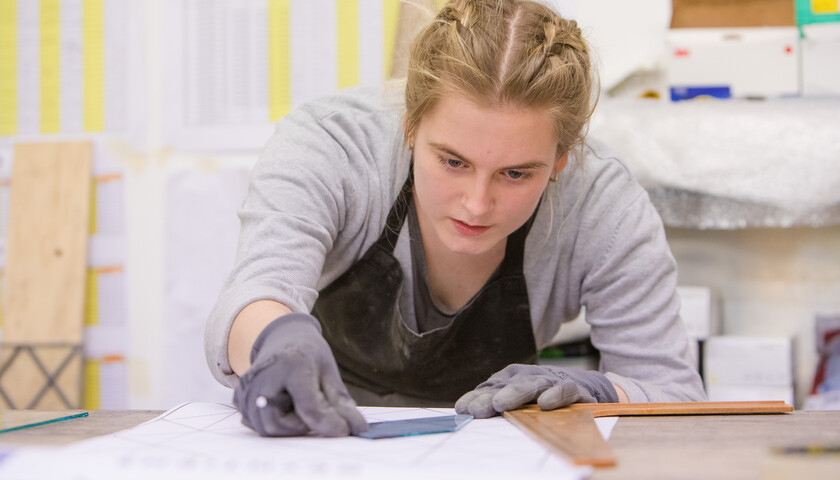 A student working on a piece of stained glass.