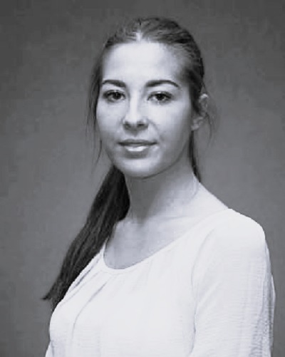 Professional headshot of Kirsty Dunn, a woman with dark hair pulled back, looking directly at the camera.