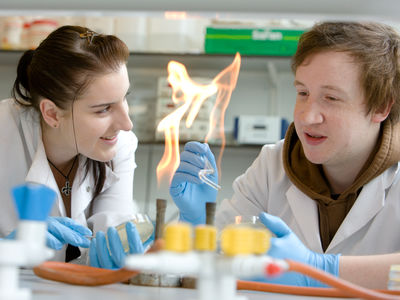 Two students conducting an experiment with a Bunsen burner