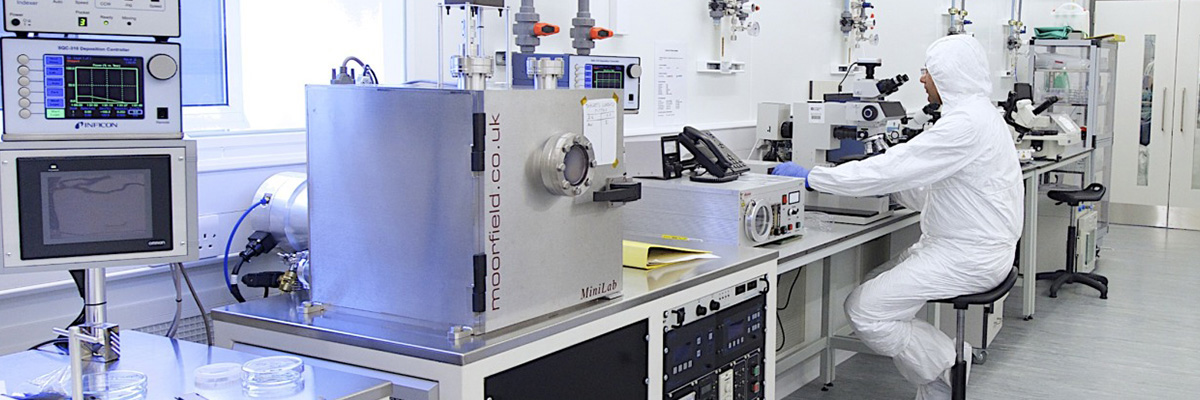 A person working with equipment in a clean room laboratory