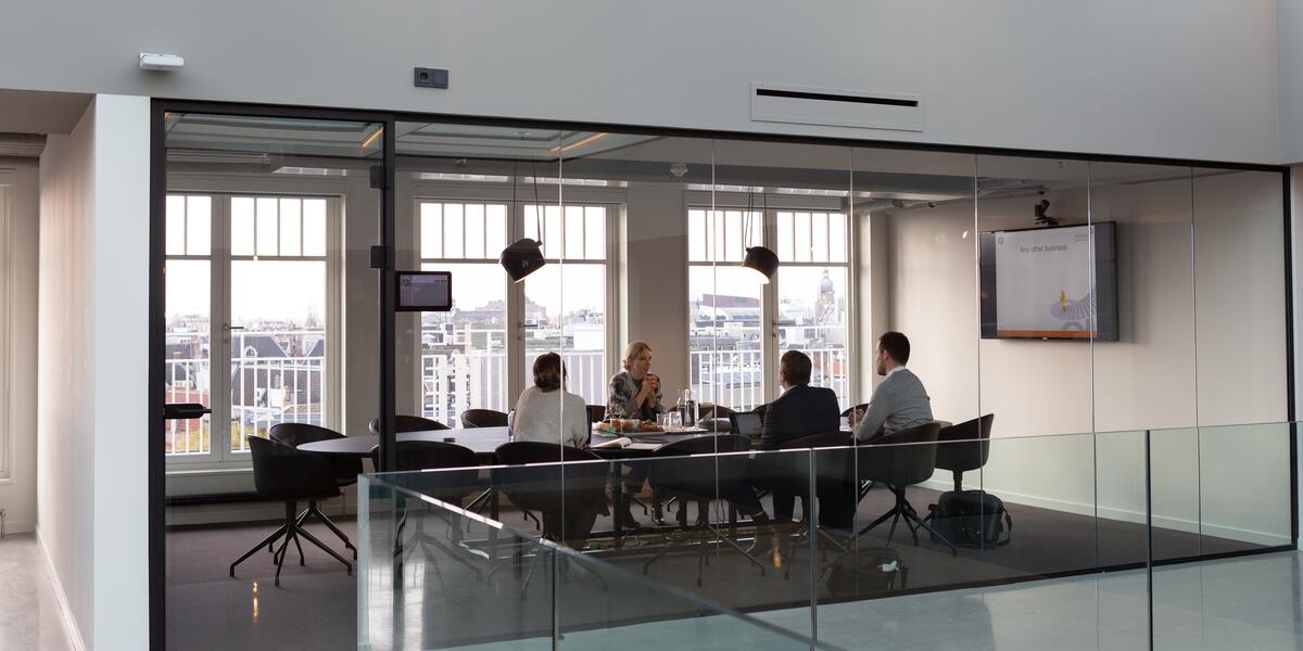 Several people sitting in an office, in conference