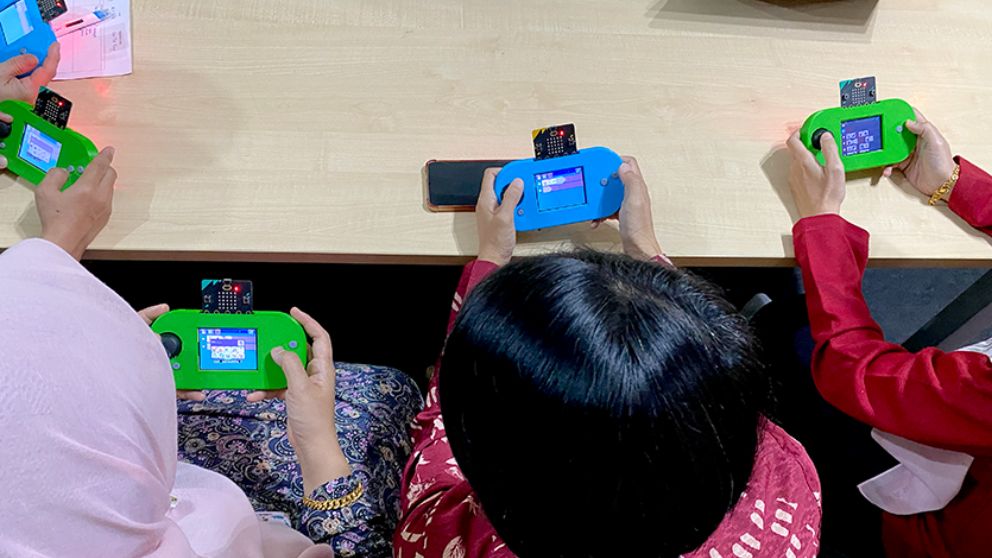 Children playing with micro:bit-powered consoles