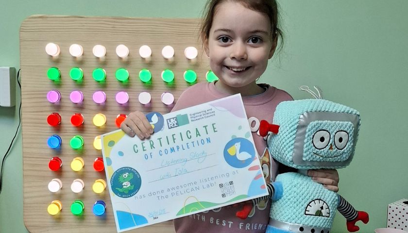 Isla holding a certificate and Beep Beep