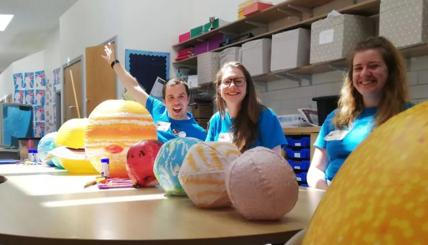 A group of student ambassadors sat down with an inflatable solar system 