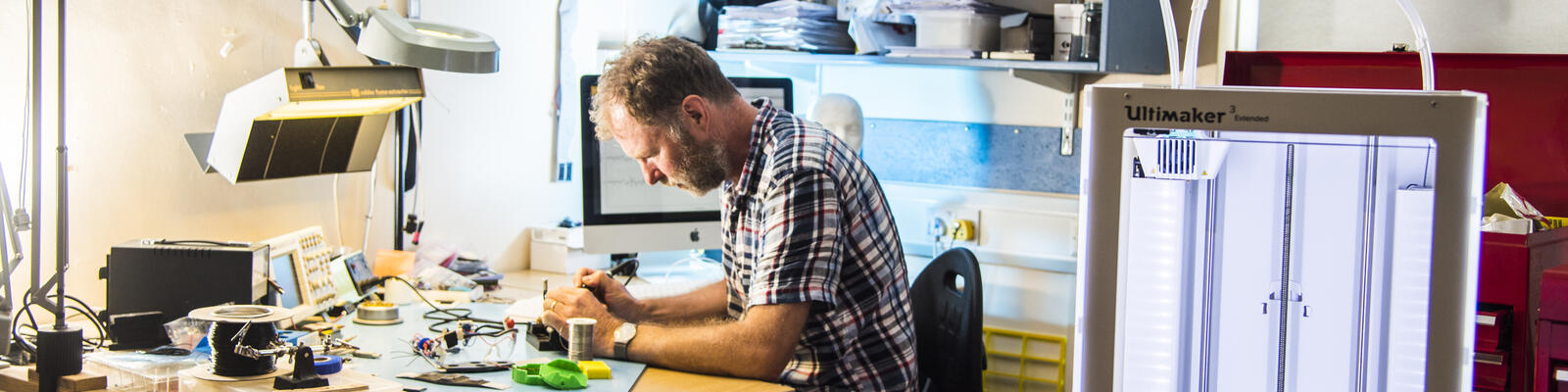 A man working on some electronics in the Physics department