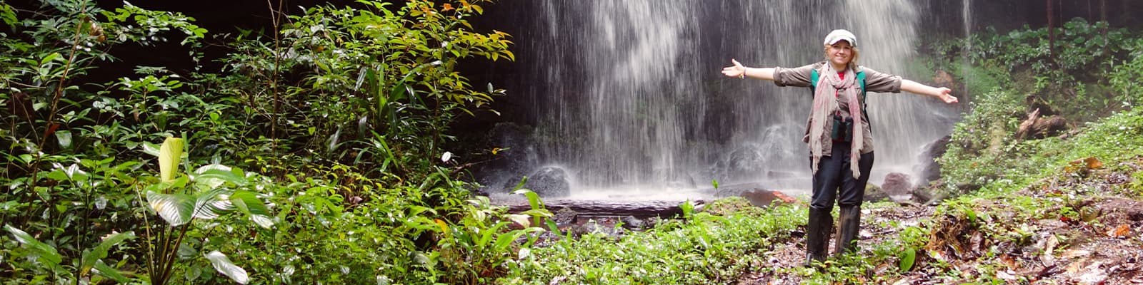 A student stood in front of a waterfall