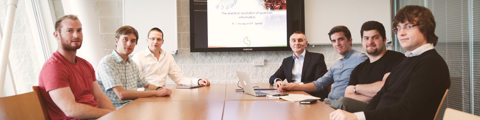 The Quantum Base team sit around a desk