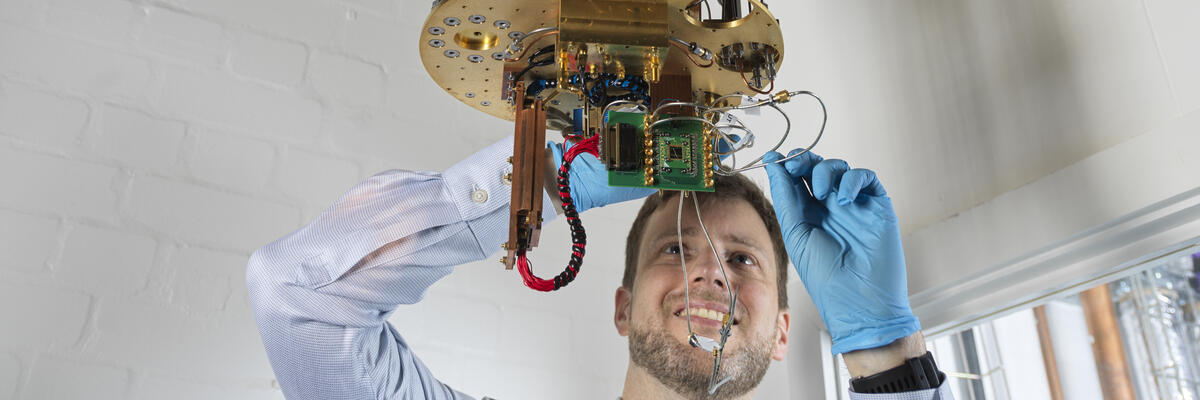 An academic examining a low temperature fridge in Physics