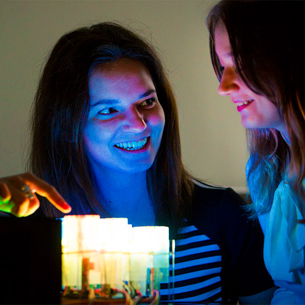 Two girls examining a computer system