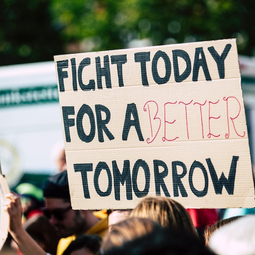 A person holding a banner saying 
