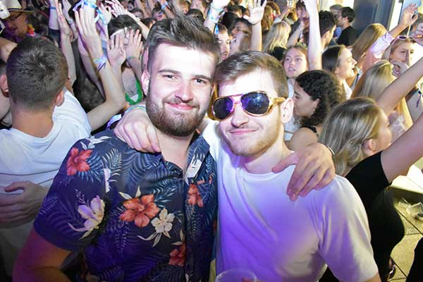 Two Furness students stood front of a crowd of people