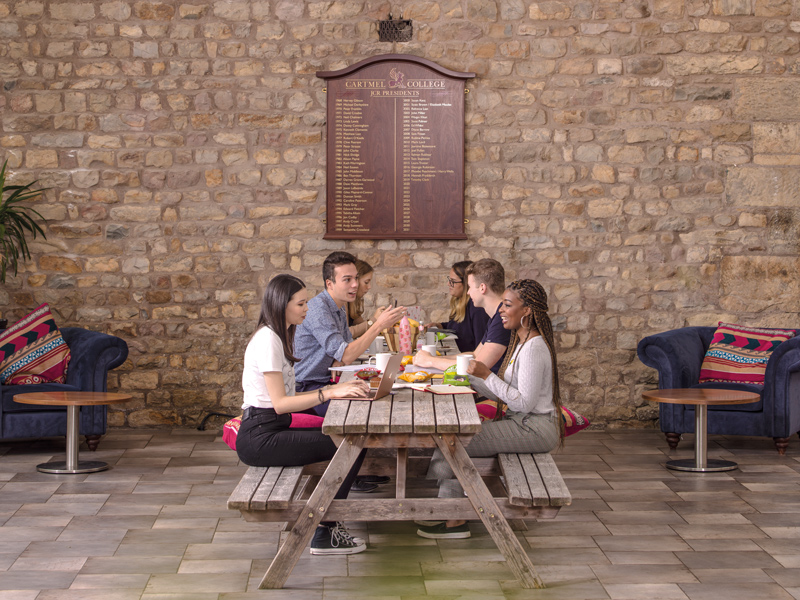 Four students sitting together for a meal at Cartmel College Barker House Farm