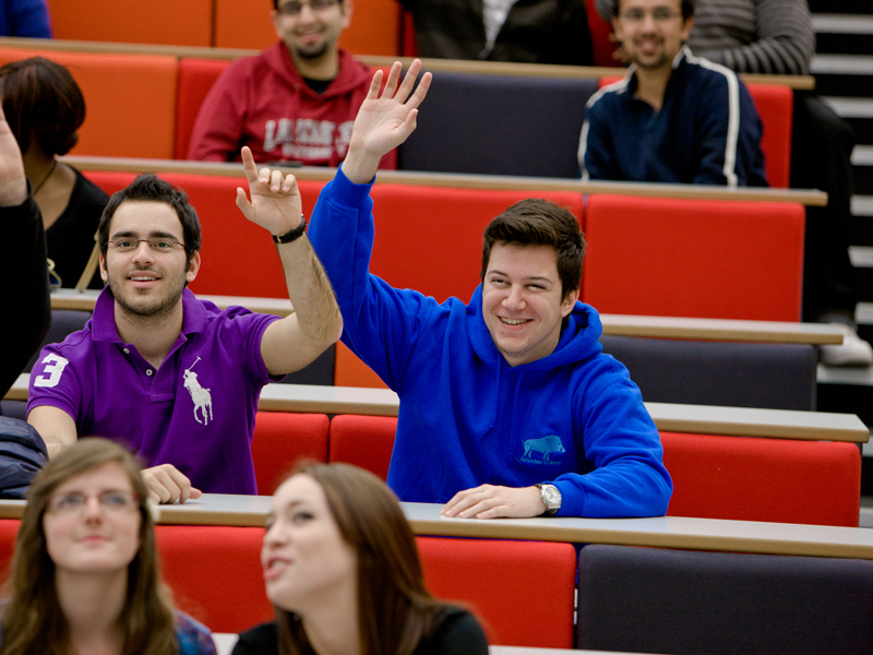 Students raising their hands during a lecture