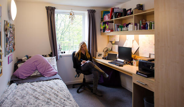 A female student studying in her bedroom.
