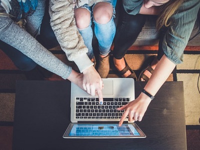 a group of students working together on a laptop